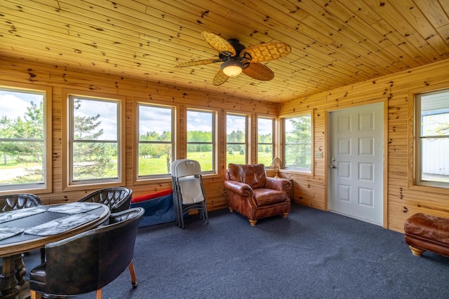 sunroom featuring a ceiling fan, wood ceiling, and a healthy amount of sunlight