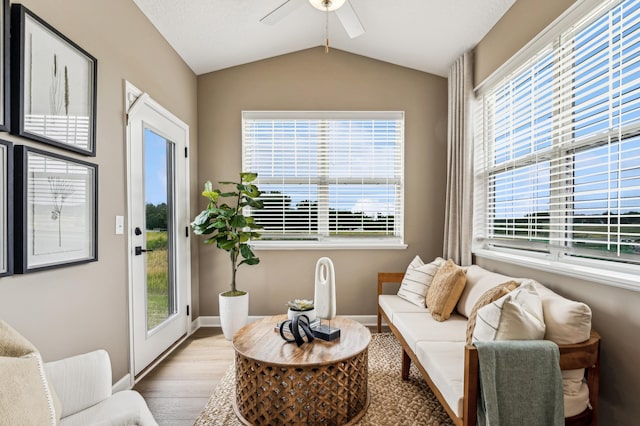 living area with lofted ceiling, ceiling fan, baseboards, and wood finished floors