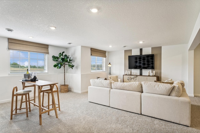 living area featuring a textured ceiling, carpet floors, recessed lighting, and baseboards