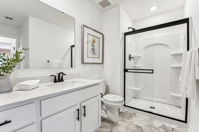 bathroom featuring toilet, a shower stall, and visible vents