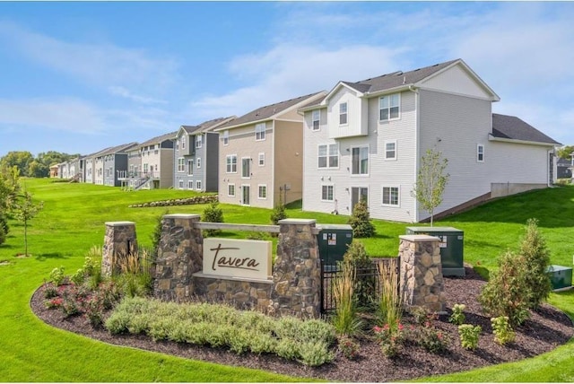 community sign featuring a residential view and a lawn