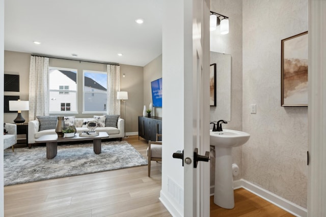 living area with baseboards, wood finished floors, and recessed lighting