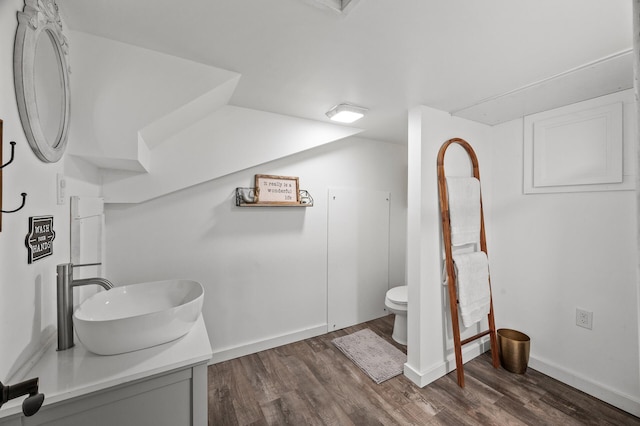 bathroom with baseboards, vanity, toilet, and wood finished floors