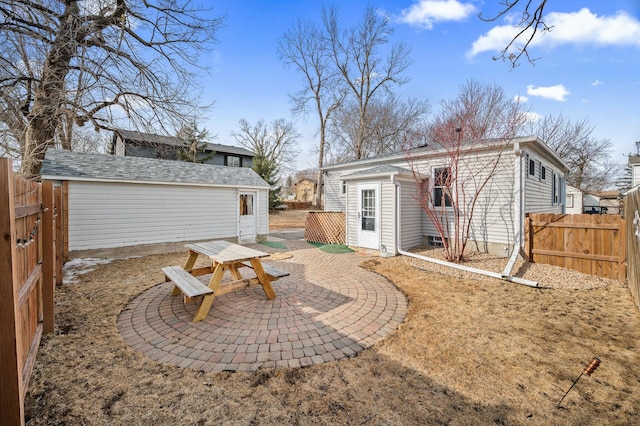 back of house with an outbuilding, a patio area, and fence