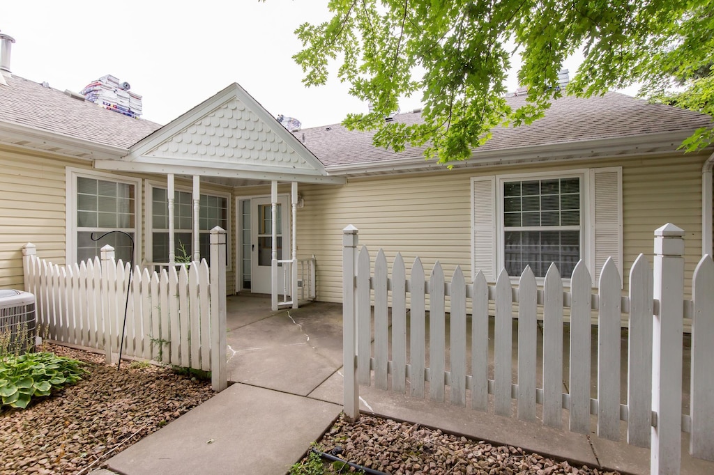 exterior space with fence and roof with shingles