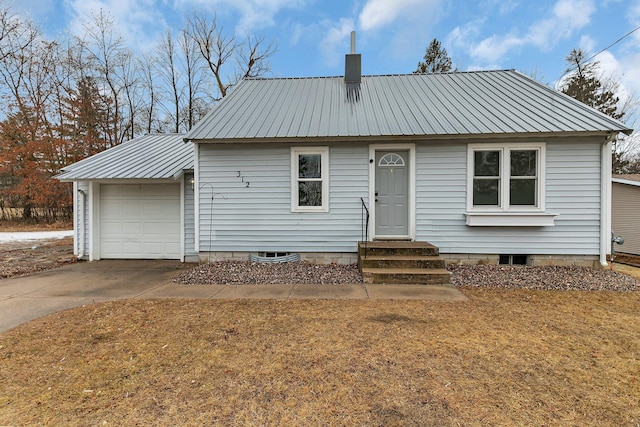 view of front facade with entry steps, a garage, metal roof, and concrete driveway