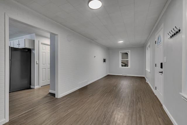 unfurnished room with dark wood finished floors, visible vents, and baseboards