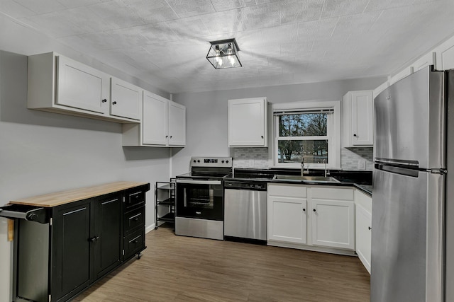 kitchen featuring white cabinetry, stainless steel appliances, and a sink