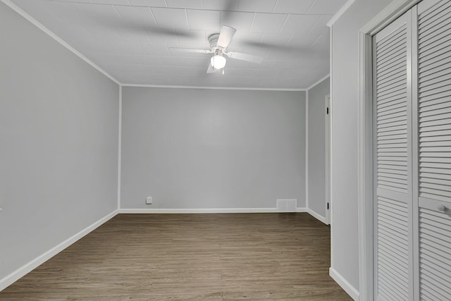 unfurnished bedroom featuring wood finished floors, visible vents, baseboards, ornamental molding, and a closet