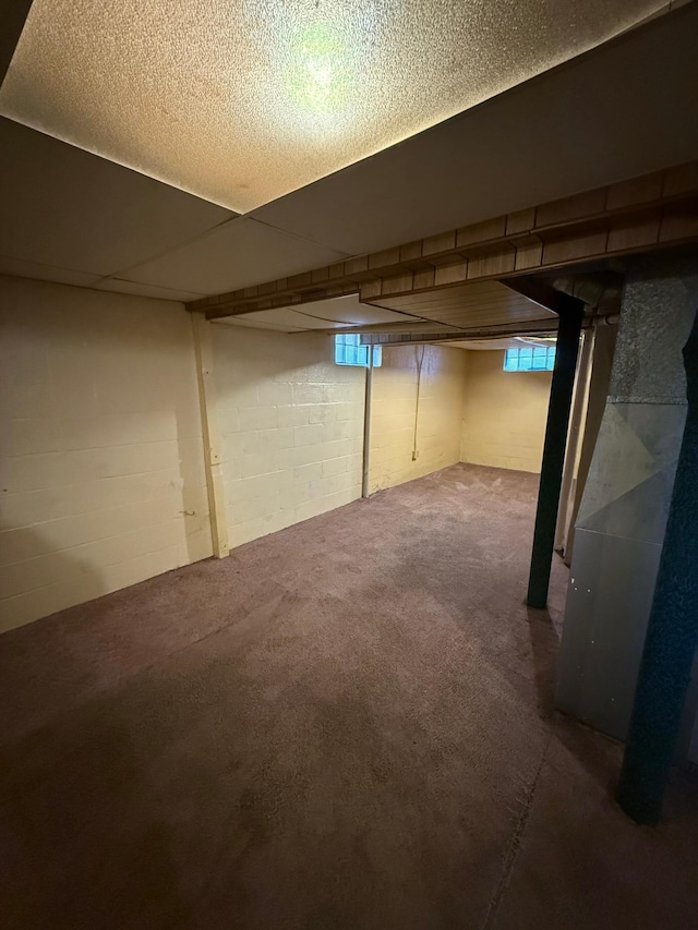 basement featuring heating unit and carpet flooring