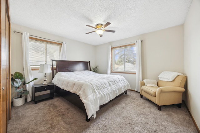 bedroom featuring multiple windows, a ceiling fan, carpet flooring, and a textured ceiling