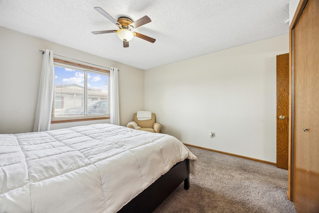 bedroom with a ceiling fan, a textured ceiling, a closet, carpet, and baseboards