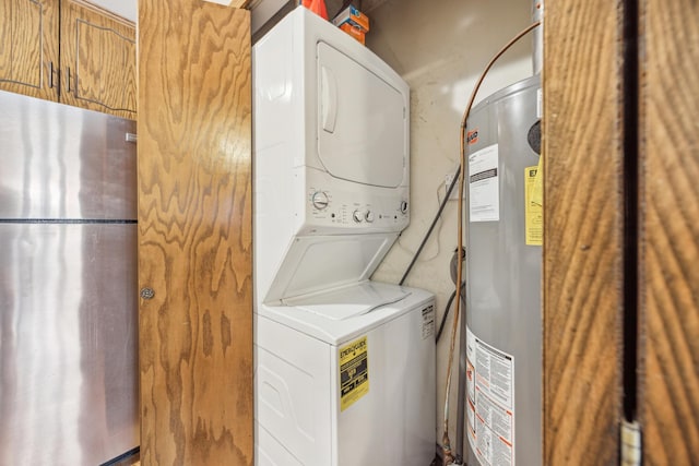 laundry area with laundry area, water heater, and stacked washing maching and dryer