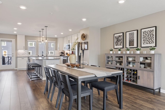 dining space featuring recessed lighting, an inviting chandelier, and dark wood finished floors