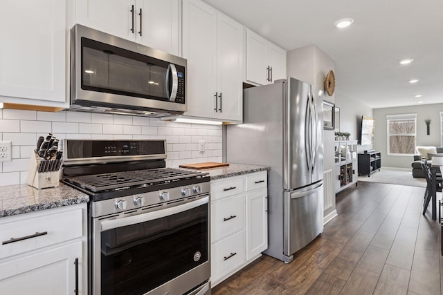 kitchen featuring tasteful backsplash, appliances with stainless steel finishes, dark wood finished floors, and white cabinetry