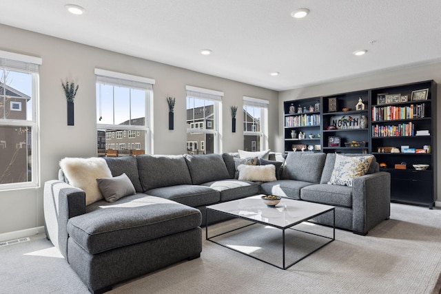 living area featuring recessed lighting, visible vents, baseboards, and light colored carpet