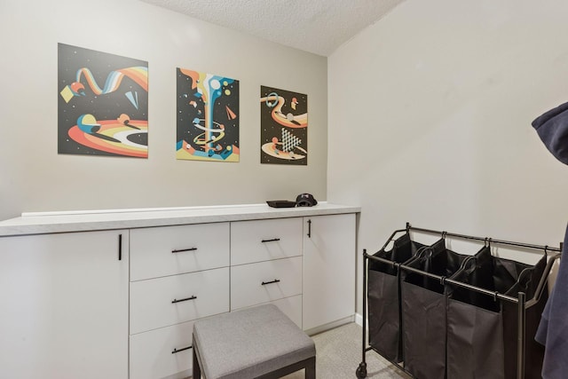 bedroom with light carpet and a textured ceiling