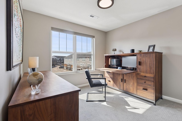 office area featuring light colored carpet, visible vents, and baseboards