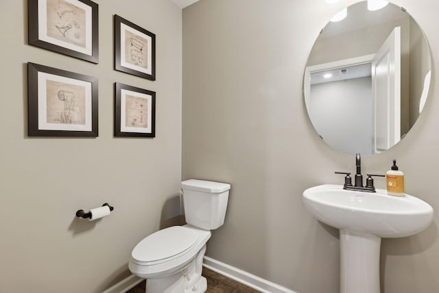 bathroom featuring toilet and baseboards