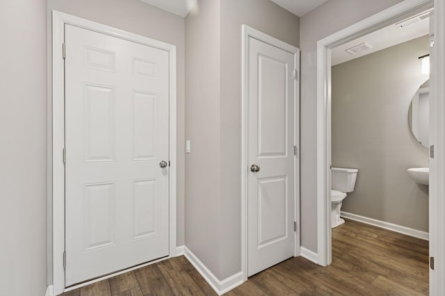 interior space with visible vents, toilet, baseboards, and wood finished floors