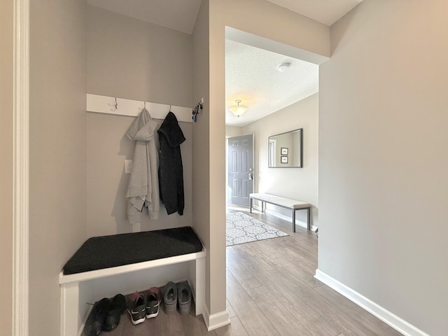 mudroom featuring baseboards and light wood finished floors