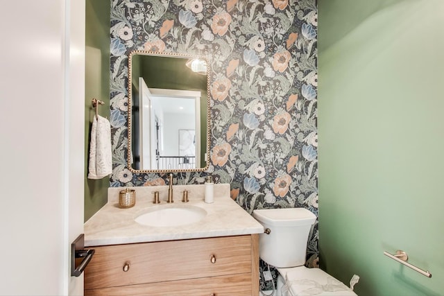 702 Summer Ave SE, New Prague, MN 56071 - bathroom featuring wallpapered walls, toilet, and vanity