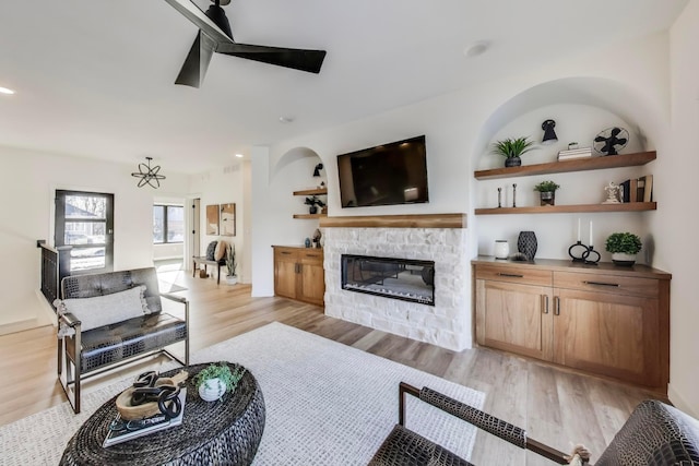 702 Summer Ave SE, New Prague, MN 56071 - living area featuring recessed lighting, light wood-style flooring, a stone fireplace, and ceiling fan