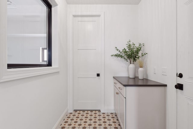 doorway with light floors and baseboards