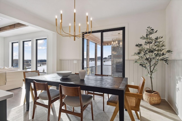 dining space featuring a wealth of natural light, light tile patterned floors, beamed ceiling, and an inviting chandelier