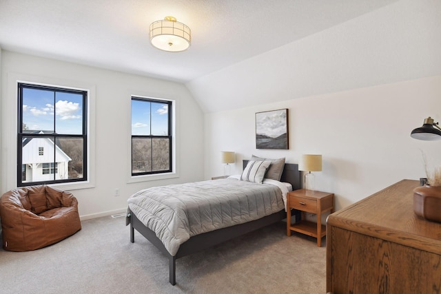 bedroom featuring light colored carpet, vaulted ceiling, and baseboards