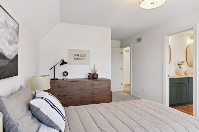 bedroom featuring ensuite bath and visible vents