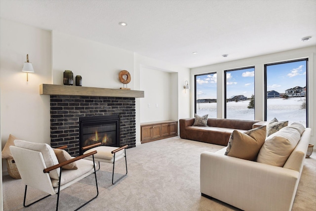 living room with light carpet, a brick fireplace, and a water view