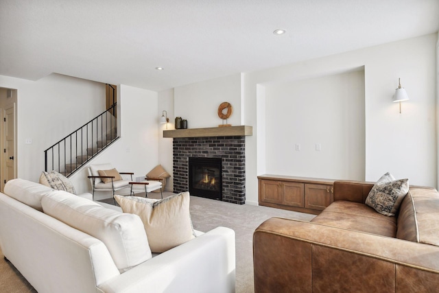 living area featuring carpet, a brick fireplace, recessed lighting, and stairs