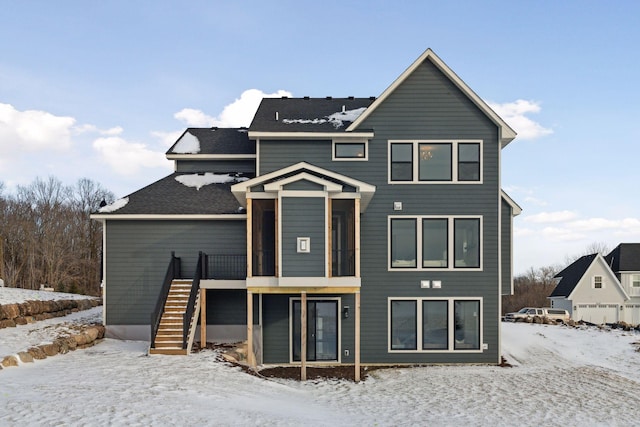 snow covered rear of property featuring stairway and a wooden deck