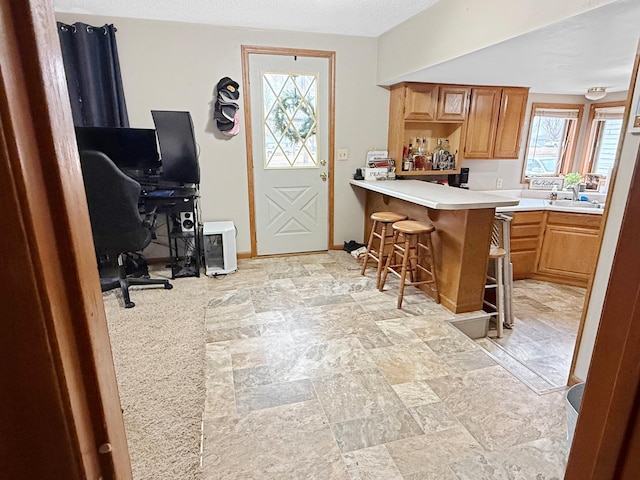 kitchen with light countertops, a breakfast bar area, plenty of natural light, and stone finish floor