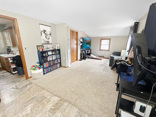 interior space featuring carpet floors, a sink, vaulted ceiling, a textured ceiling, and baseboards