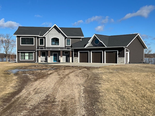 view of front of home featuring an attached garage, covered porch, stone siding, and dirt driveway