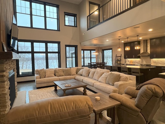 living area featuring recessed lighting, a towering ceiling, and a fireplace