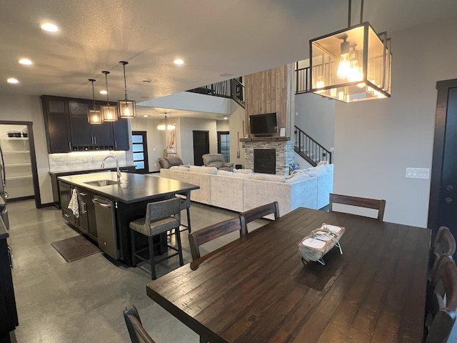 dining area featuring a chandelier, recessed lighting, a fireplace, and concrete flooring