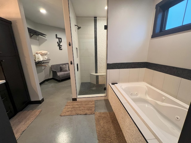 bathroom featuring a tub with jets, a stall shower, concrete floors, and baseboards