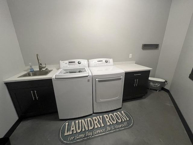 washroom with a sink, cabinet space, and separate washer and dryer