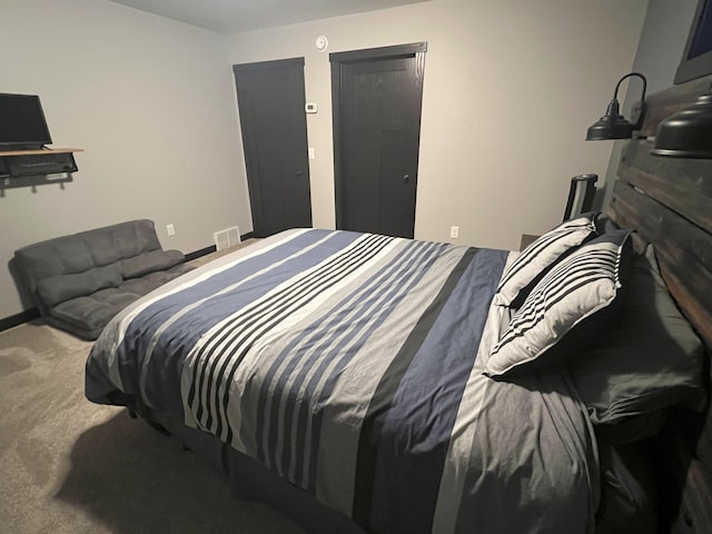 carpeted bedroom featuring visible vents and baseboards