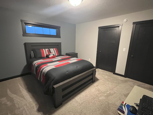 bedroom with baseboards, carpet floors, and a textured ceiling