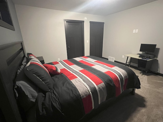 carpeted bedroom featuring visible vents and baseboards