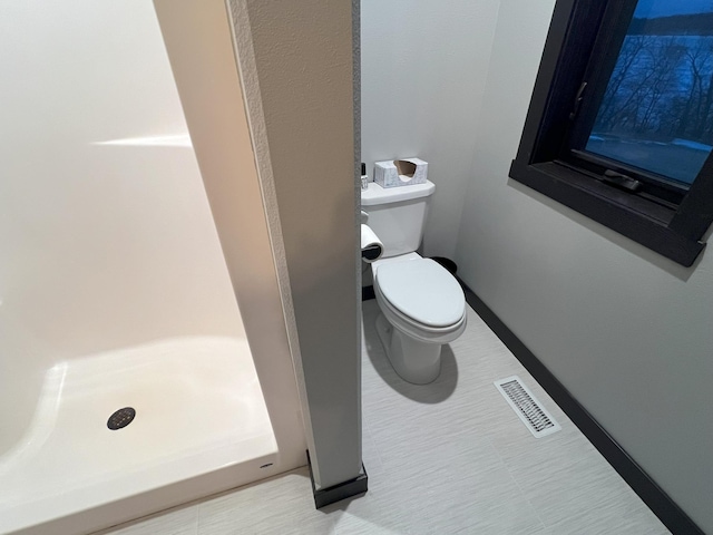 bathroom featuring visible vents, a shower stall, toilet, and baseboards