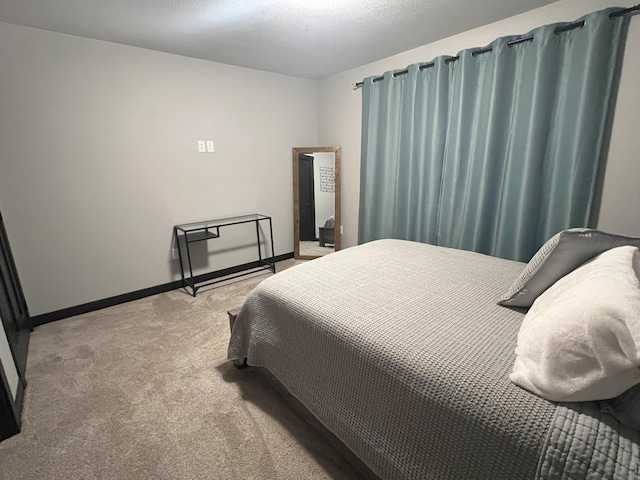 bedroom with baseboards and light colored carpet