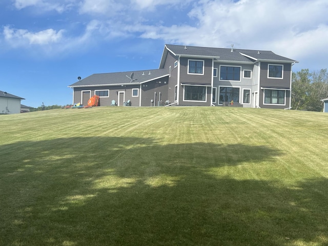 rear view of property featuring a lawn