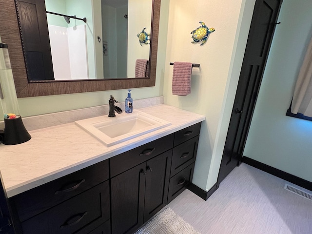 bathroom featuring visible vents, vanity, and baseboards