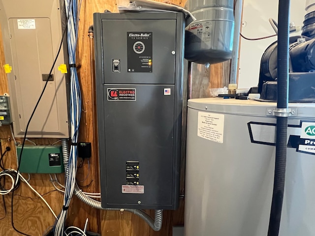 utility room featuring electric panel and water heater