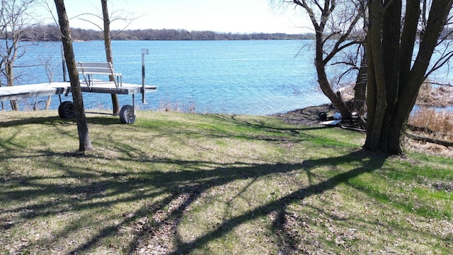 dock area with a water view and a yard